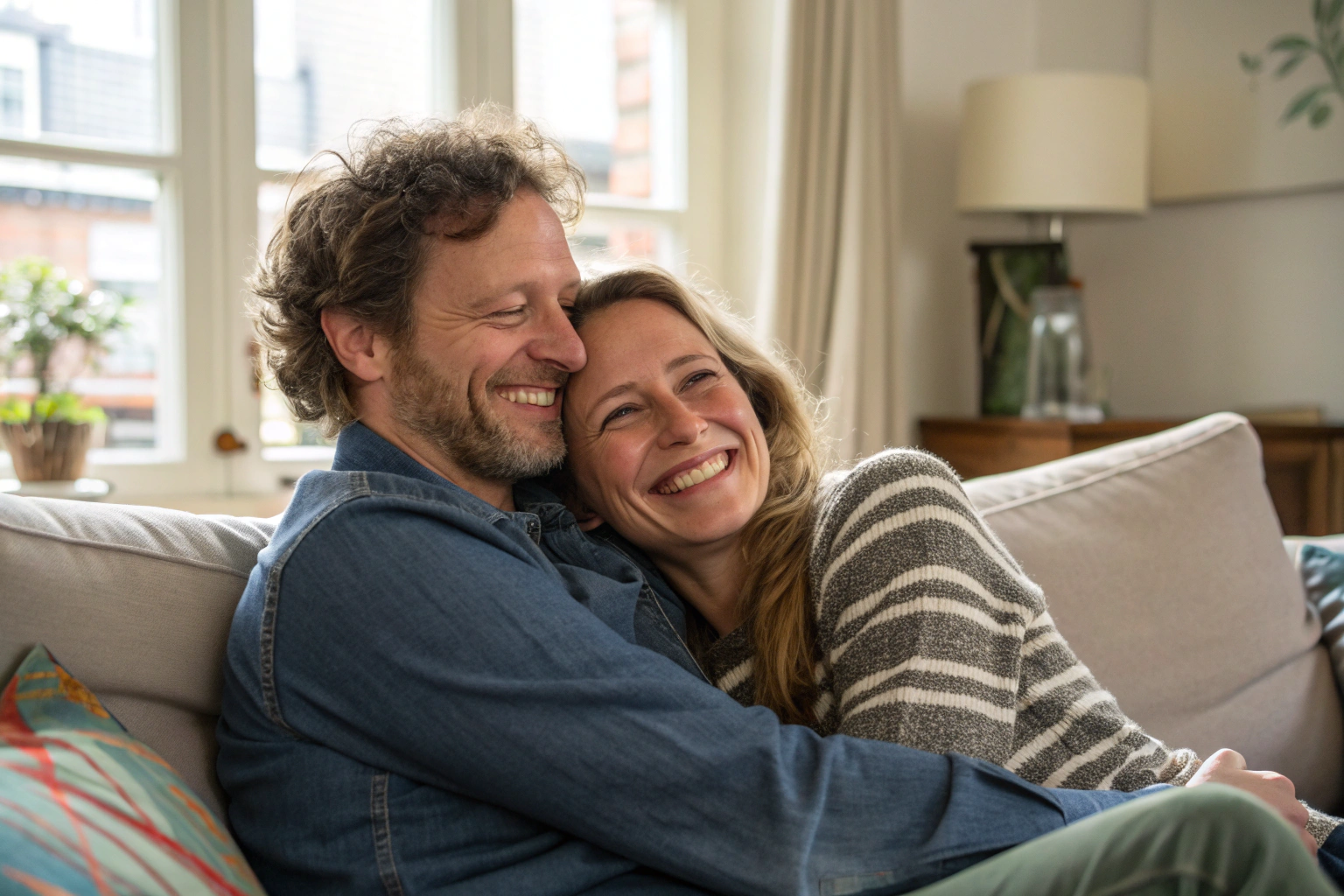 Liefdevol koppel op bank toont intimiteit in relatie door warme omhelzing