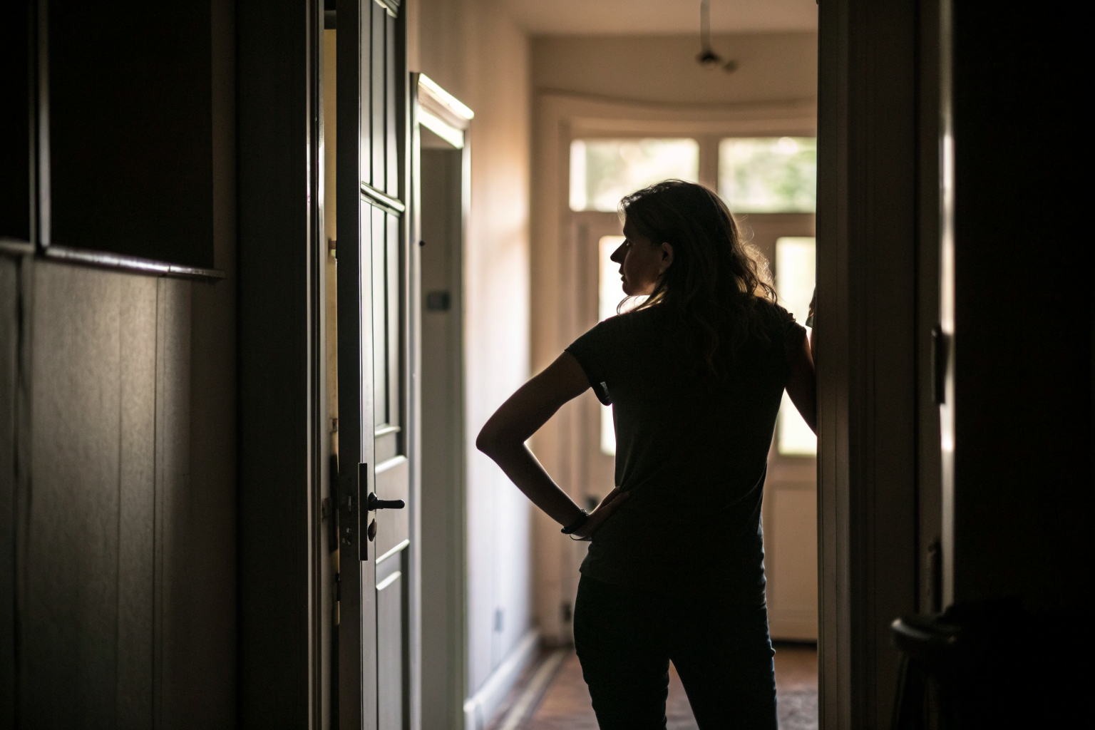 Vrouw in deuropening kijkt terug: de wond die je meebrengt in je relatie