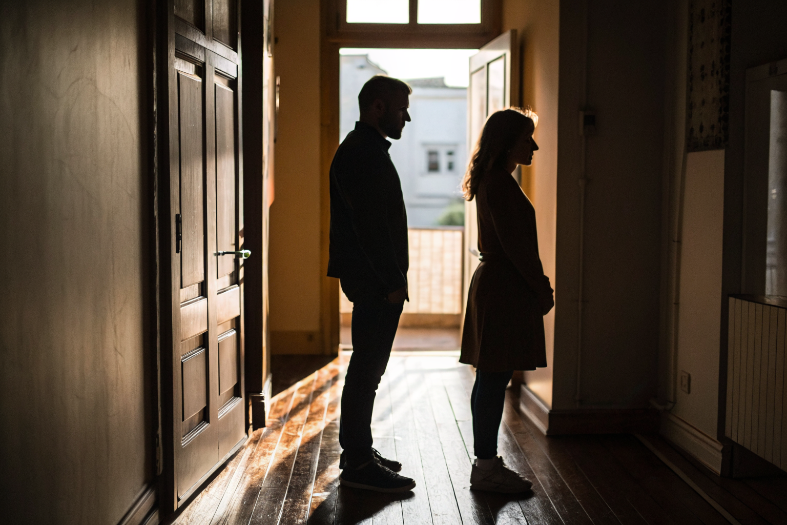 Silhouet van koppel rug aan rug in gang: erfenis van je jeugd bepaalt je partnerkeuze