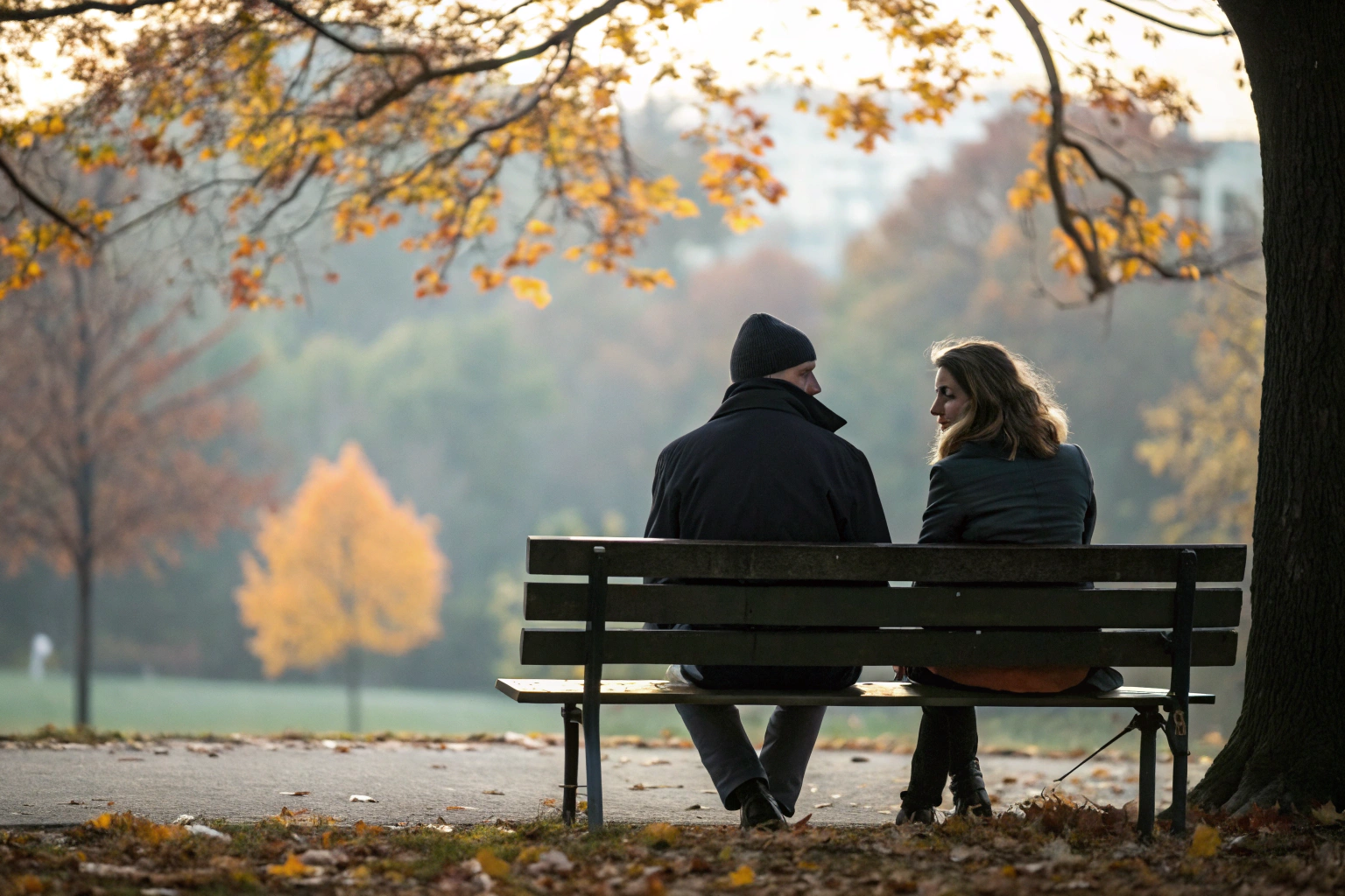 Stel zit ver uit elkaar op bankje als teken van emotionele afstand