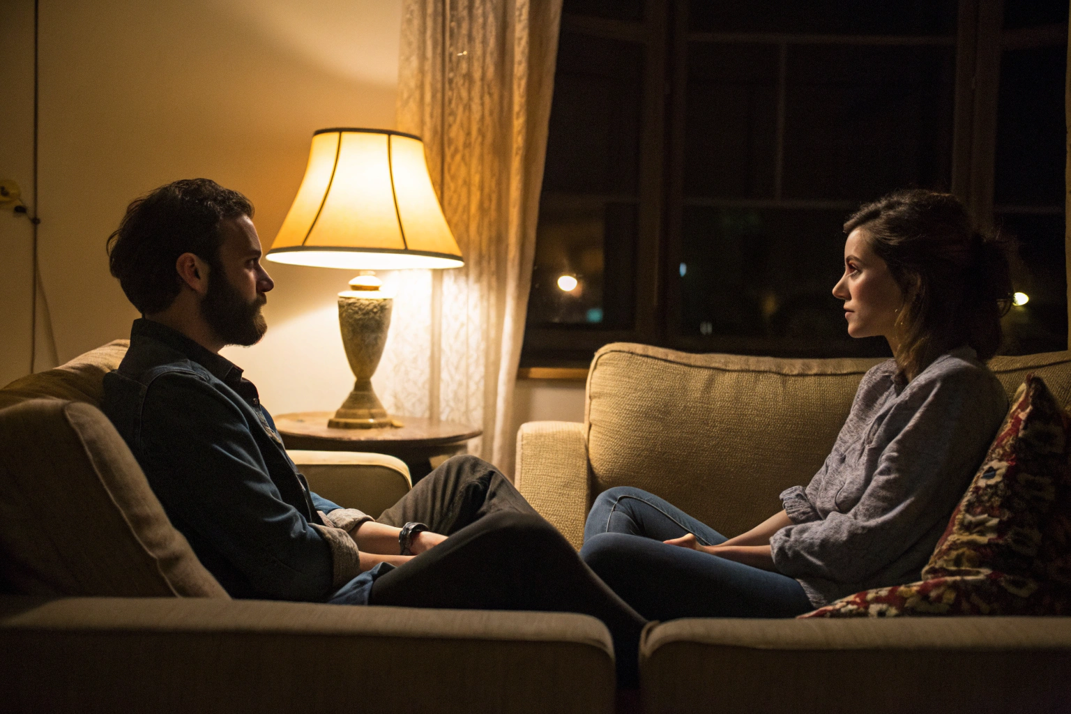 Stel zit op afstand van elkaar op de bank, emotionele kloof na baby