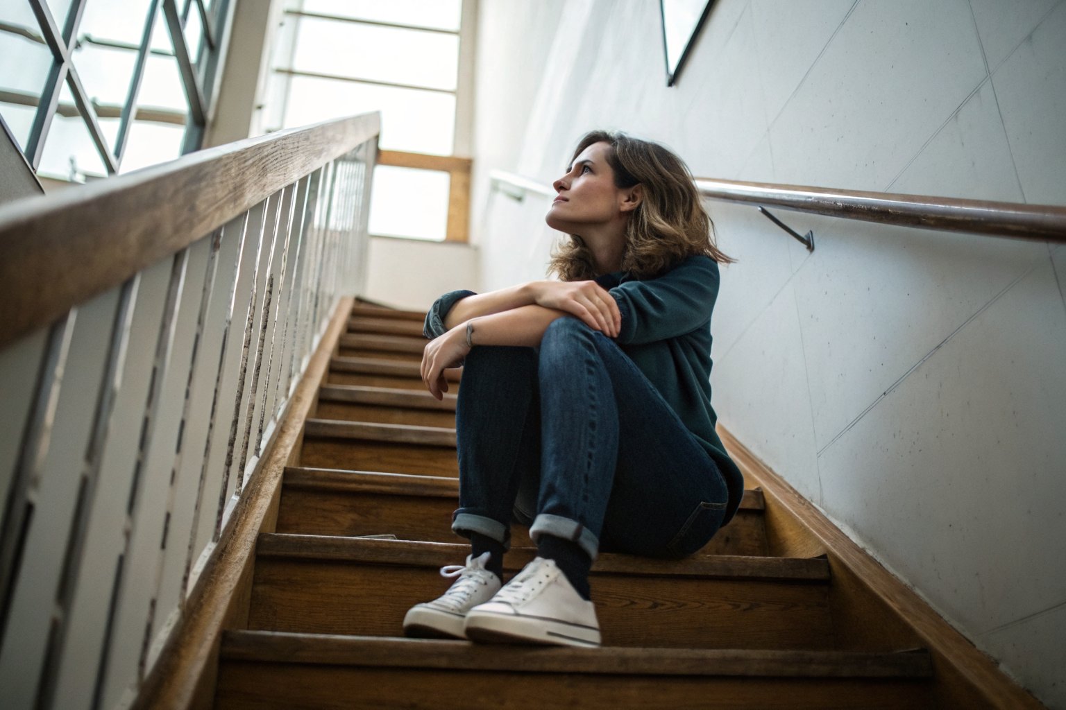 Beeld bij herstelvermogen in relaties: A woman sitting on a wooden staircase