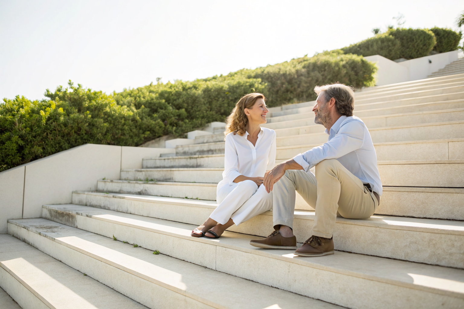 Beeld bij intentie en impact botsen: Two friends sitting on wide sunlit steps outdoors